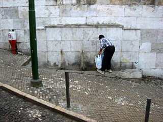 Un homme prend de l'eau à la fontaine